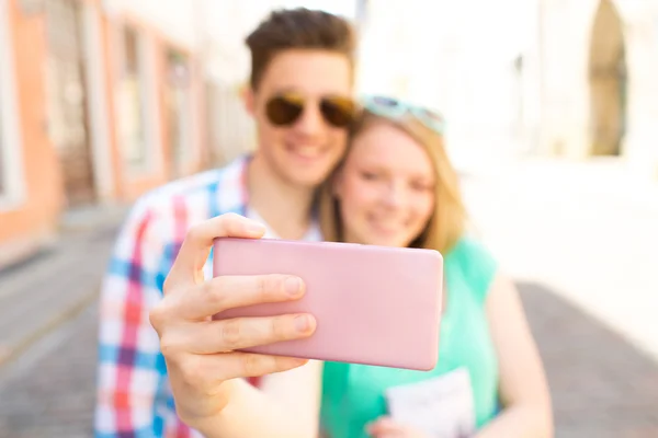 Счастливая пара делает селфи со смартфоном в городе — стоковое фото