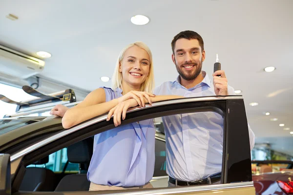 Feliz pareja comprando coche en auto show o salón —  Fotos de Stock