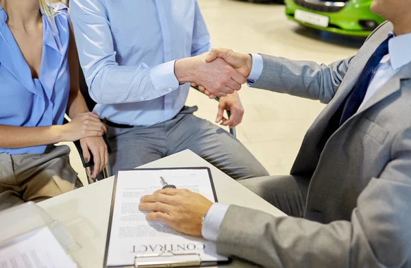 Handshake of customer and car dealer in auto salon — Stock Photo, Image