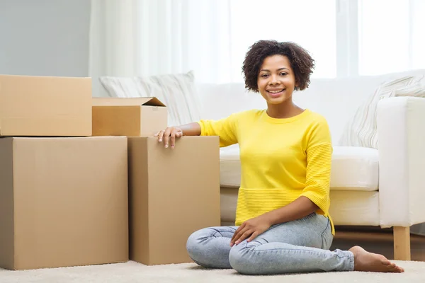 Gelukkig Afrikaanse vrouw met kartonnen dozen thuis — Stockfoto