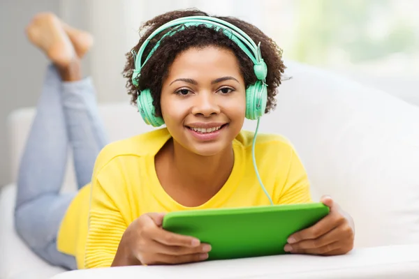 Happy african woman with tablet pc and headphones — Stock Photo, Image