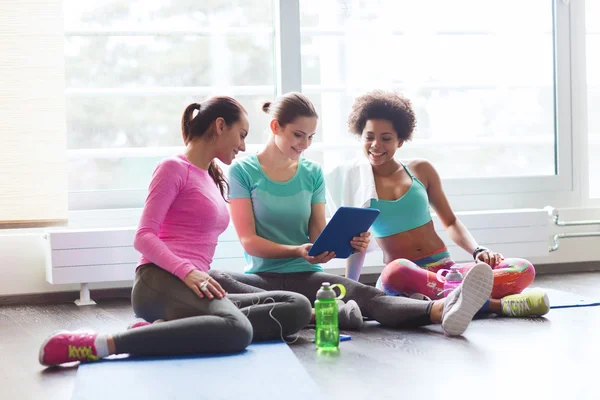 Grupp glada kvinnor med TabletPC i gymmet — Stockfoto