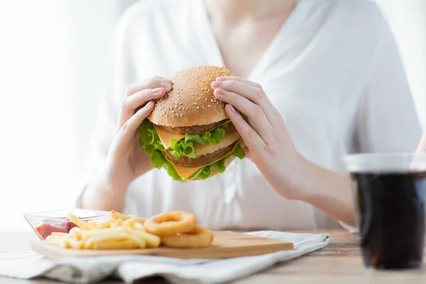 Primer plano de las manos de la mujer sosteniendo hamburguesa — Foto de Stock