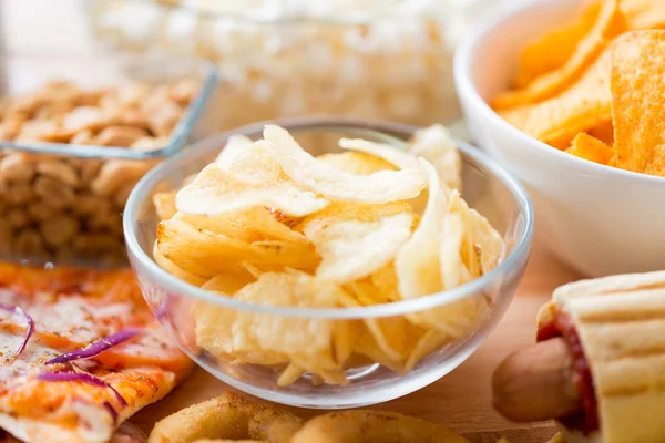 Close up of crunchy potato crisps in glass bowl — Stock Photo, Image