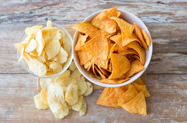 close up of potato crisps and corn nachos on table