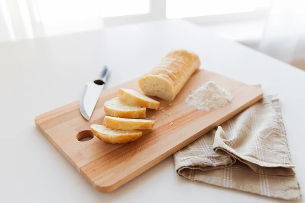 Close up of white bread or baguette and knife — Stock Photo, Image