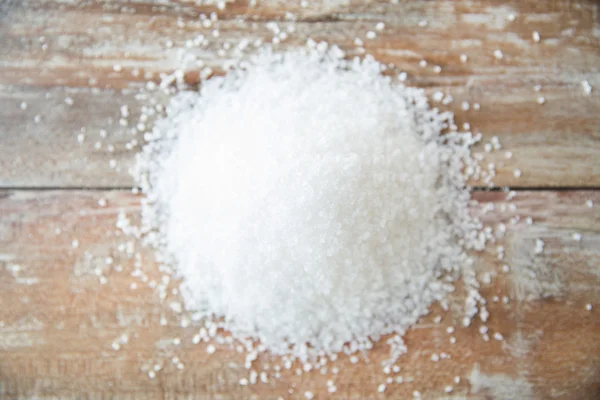 Detailní záběr bílé soli haldy na dřevěný stůl — Stock fotografie