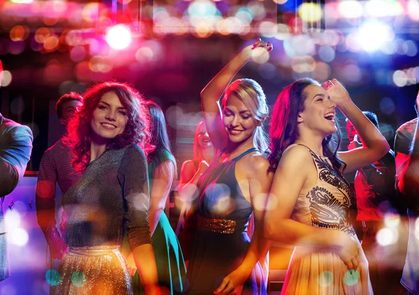 Happy friends dancing in club with holidays lights Stock Picture