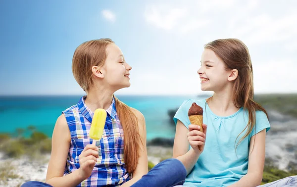 Счастливые девчонки едят мороженое на пляже Лицензионные Стоковые Фото