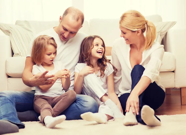 parents and two girls sitting on floor at home