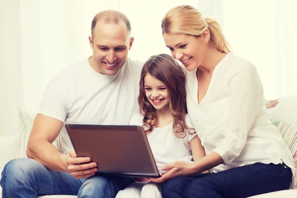 Parents et petite fille avec ordinateur portable à la maison — Photo