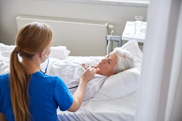 Infermiera con stetoscopio e donna anziana in clinica — Foto Stock