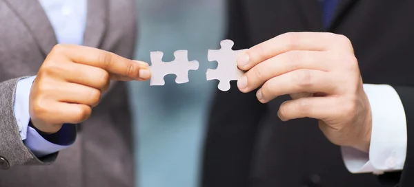 Businessman and businesswoman with puzzle pieces — Stock Photo, Image