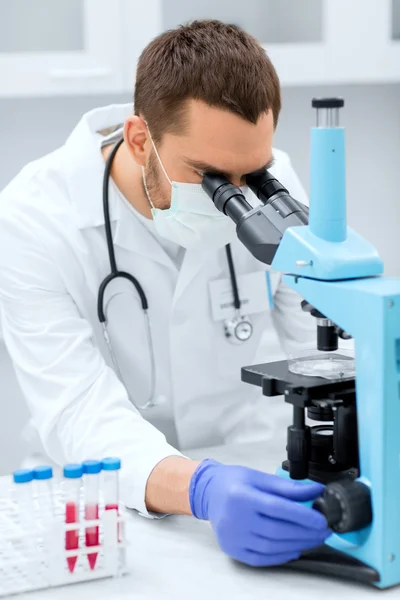 Молодий вчений шукає мікроскоп в лабораторії — стокове фото