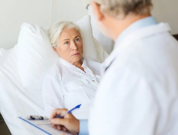 Donna anziana e medico con appunti in ospedale — Foto Stock