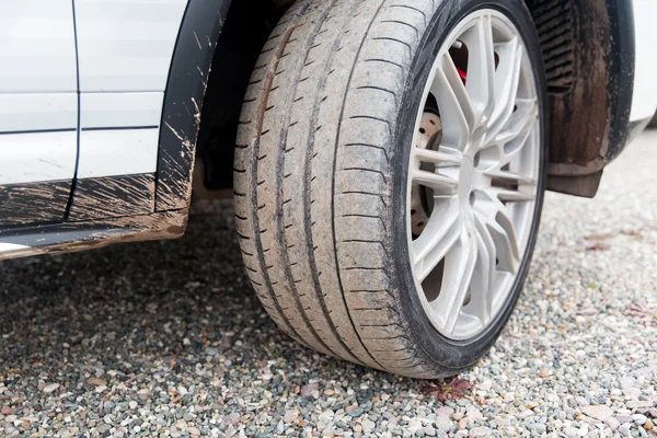 Close up of dirty car wheel on ground — Stock Photo, Image