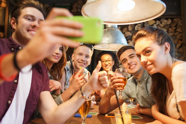 Boldog meg smartphone, figyelembe véve a selfie, a bar — Stock Fotó