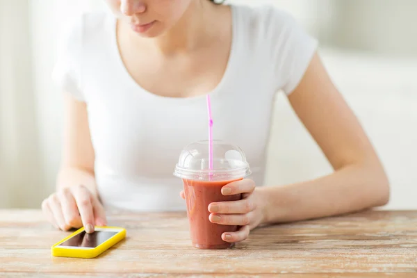 Close up of woman with smartphone and smoothie — Stock Photo, Image