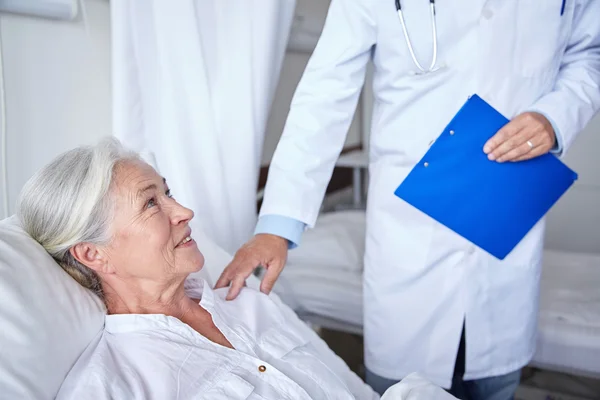 Médecin visitant heureuse femme âgée à l'hôpital — Photo