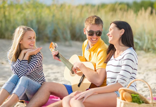 Grupo de amigos felizes tocando guitarra na praia — Fotografia de Stock