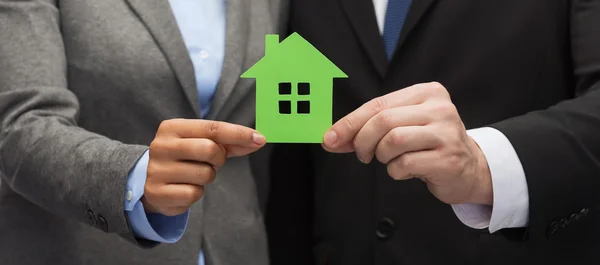 Businessman and businesswoman holding green house — Stock Photo, Image