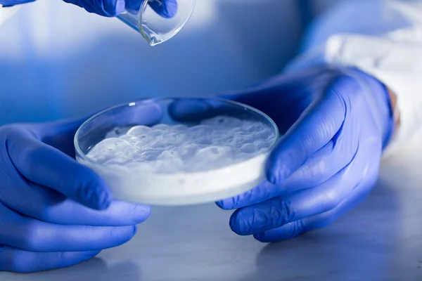 Close up of scientists hands with chemicals in lab — Stock Photo, Image