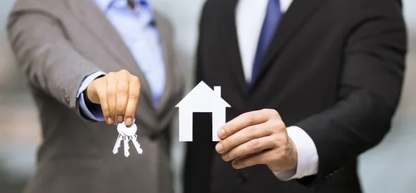 Businessman and businesswoman holding white house — Stock Photo, Image