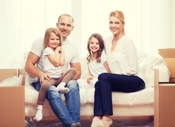 Smiling parents and two little girls at new home Royalty Free Stock Images