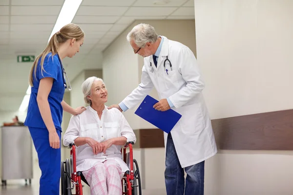 Medics and senior woman in wheelchair at hospital — Stock Photo, Image