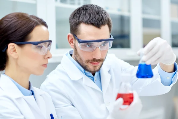 Jóvenes científicos haciendo pruebas o investigaciones en laboratorio —  Fotos de Stock