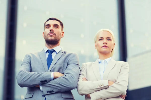 Hommes d'affaires sérieux debout au-dessus de l'immeuble de bureaux — Photo