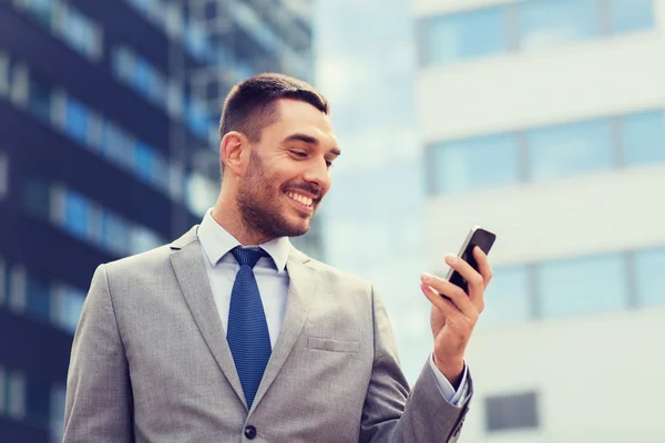 Usmíval se podnikatel s smartphone venku — Stock fotografie