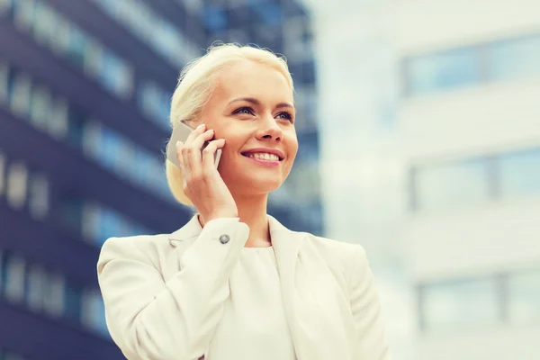 Femme d'affaires souriante avec smartphone en plein air — Photo