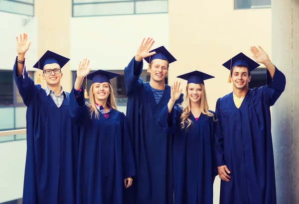 Grupa uśmiechający się uczniów w mortarboards — Zdjęcie stockowe