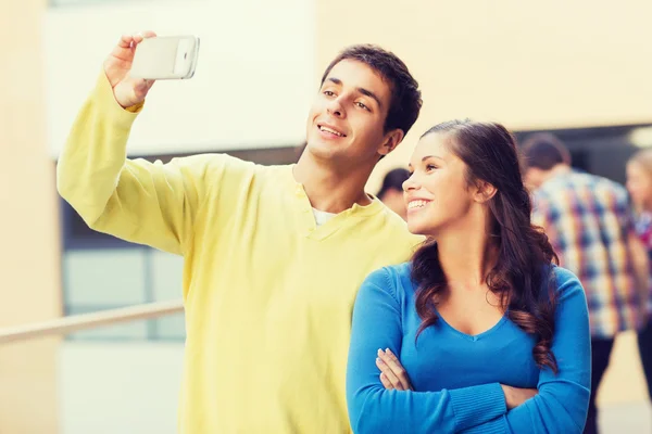 Groep lachende studenten met smartphone outdoors — Stockfoto