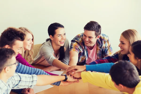 Groep lachende studenten met de hand op de top — Stockfoto