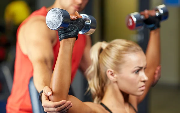 Uomo e donna con manubri in palestra — Foto Stock