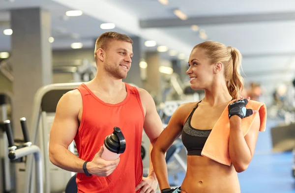 Glimlachende man en vrouw praten in de sportschool — Stockfoto