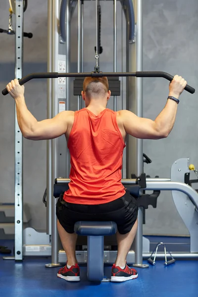 케이블 기계 체육관에서 근육을 flexing 남자 — 스톡 사진