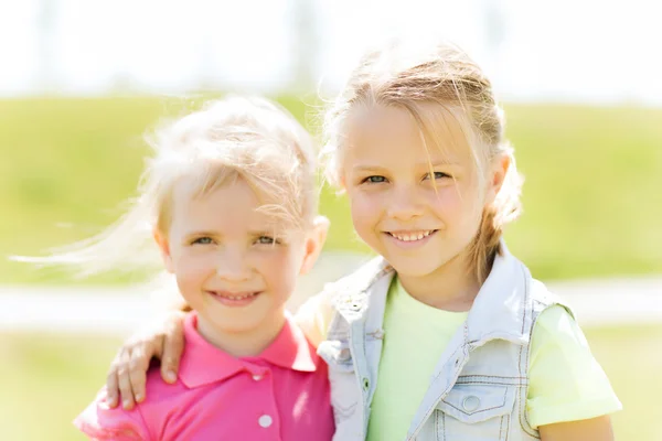 Gelukkig weinig meisjes buitenshuis knuffelen op de zomer — Stockfoto