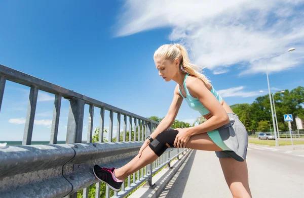 Junge Frau mit verletztem Knie oder Bein im Freien — Stockfoto