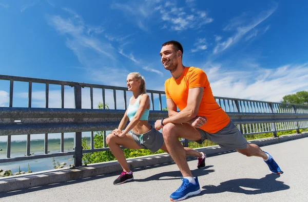 smiling couple stretching outdoors