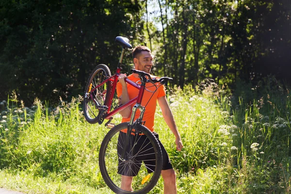 Šťastný mladý muž jedoucí na kole venku — Stock fotografie
