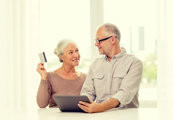 Feliz pareja de ancianos con tableta PC y tarjeta de crédito —  Fotos de Stock