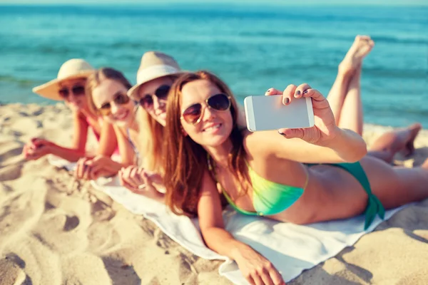 Nahaufnahme lächelnder Frauen mit Smartphone am Strand — Stockfoto