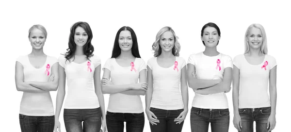 Mujeres sonrientes con cintas de conciencia de cáncer rosa — Foto de Stock