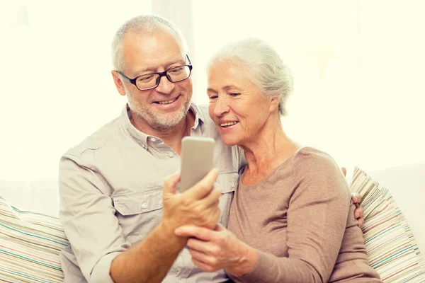 Glückliches Seniorenpaar mit Smartphone zu Hause — Stockfoto