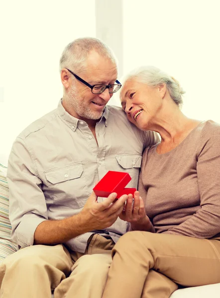Szczęśliwa para starszy z czerwonym pudełku w domu — Zdjęcie stockowe
