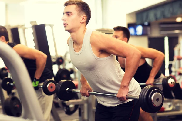 Gruppo di uomini con bilancieri in palestra — Foto Stock