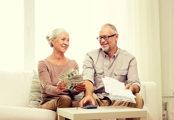 Seniorenpaar mit Geld und Taschenrechner zu Hause — Stockfoto